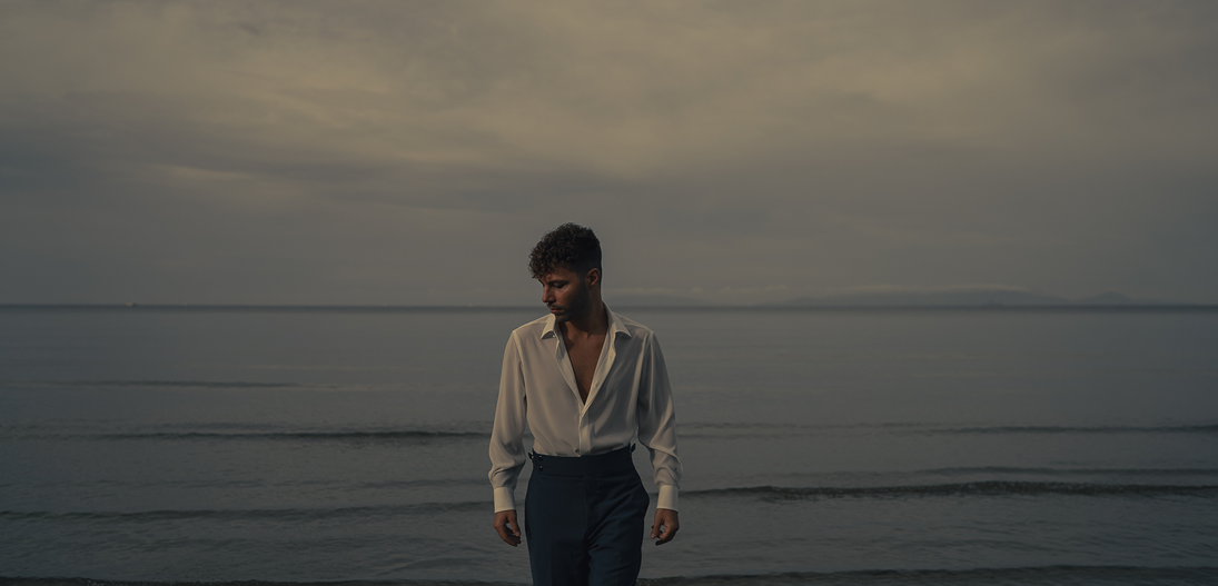 Lorenzo Gramaccia, artista visivo contemporaneo, ritratto in esterni sulla spiaggia all'alba