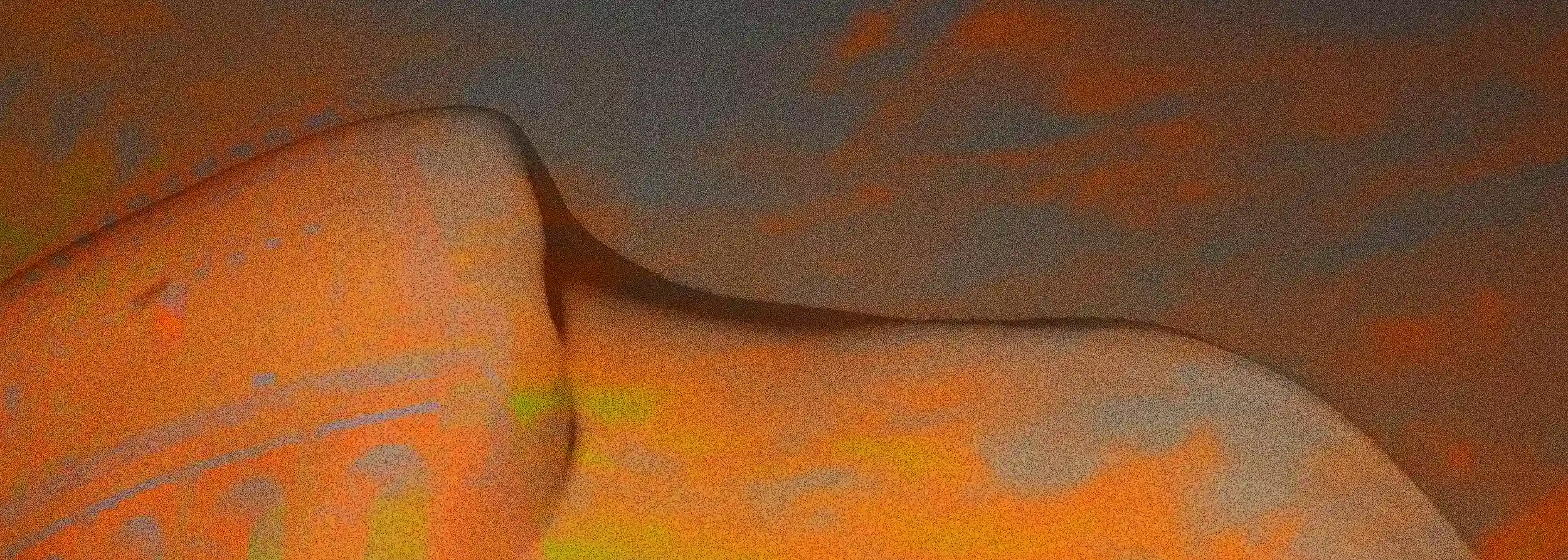 Vision of Vestigia: the soft silhouette of the body stands out against a dark sky, while the arches of ancient Roman architecture surface along the curve of the skin